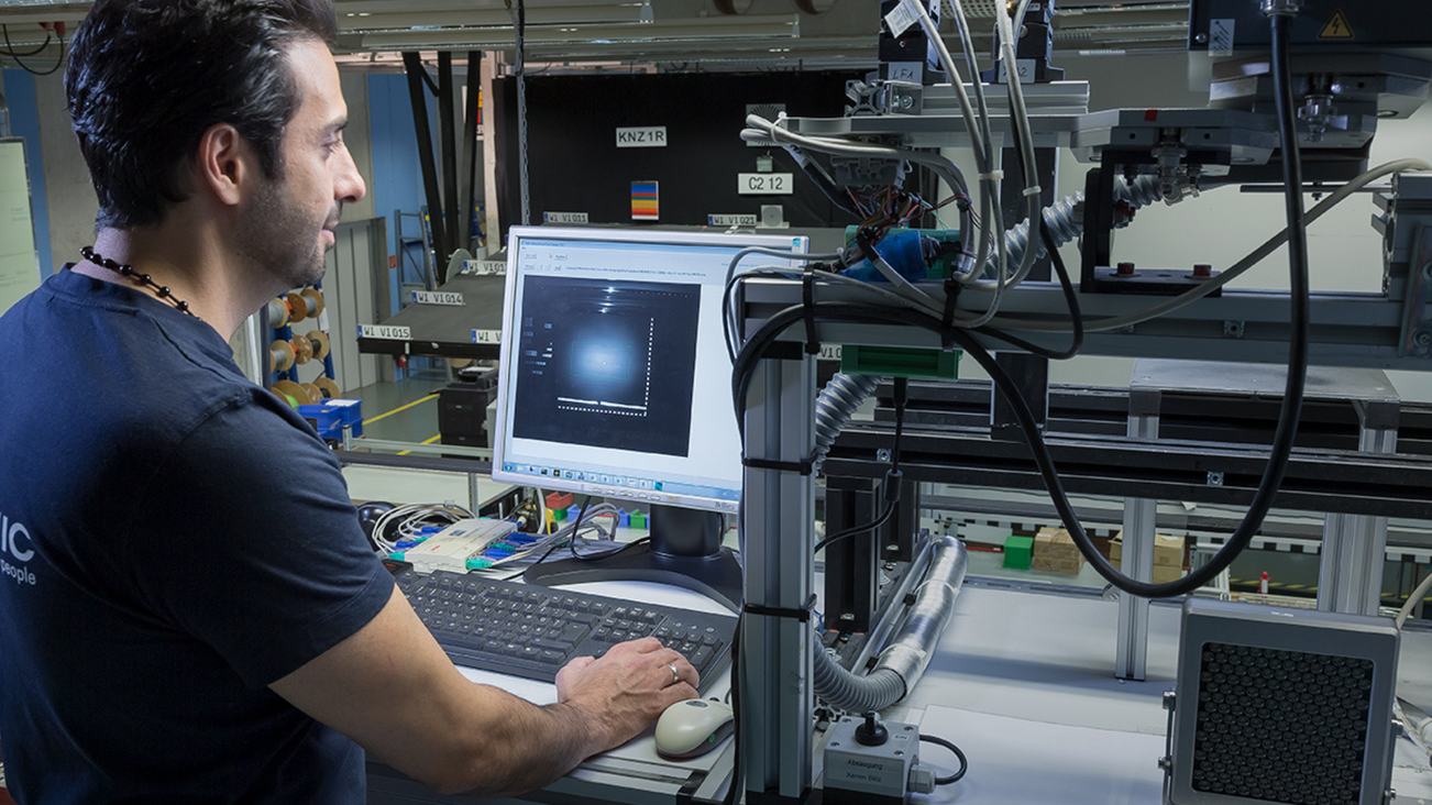 VITRONIC employee at his computer workstation directly at a test setup.